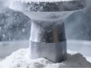 Metal additive manufacturing powder surrounding a 3D printed component during powder bed processing