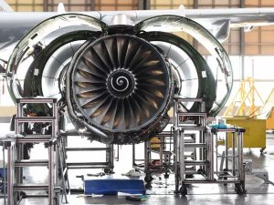 Aircraft engine assembly in an aerospace maintenance facility showing a large turbofan engine during inspection and servicing