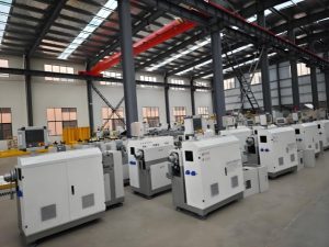 Rows of industrial metal manufacturing machines lined up inside a modern production facility floor.