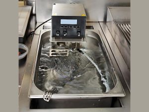 Ultrasonic cleaning machine using high-frequency waves to clean precision parts in a stainless steel tank